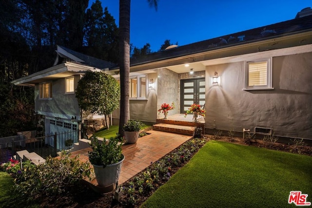 exterior space with a garage and a lawn