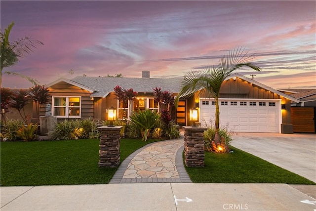 view of front of home featuring a garage and a yard