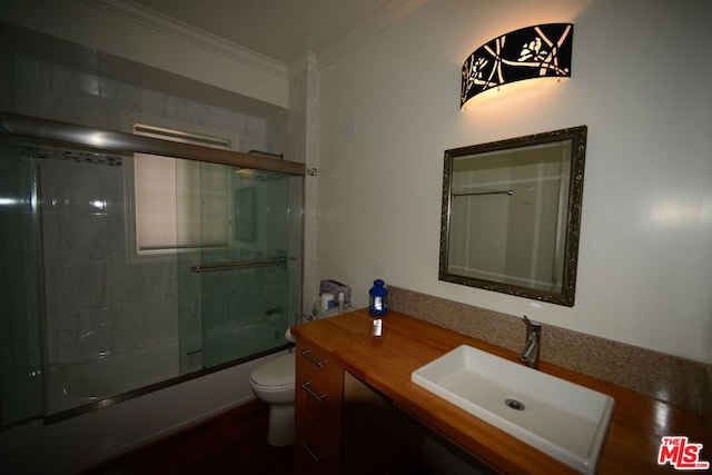 full bathroom featuring ornamental molding, vanity, enclosed tub / shower combo, and toilet