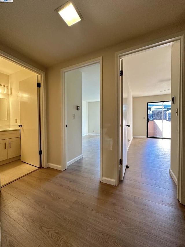 hallway with light hardwood / wood-style floors