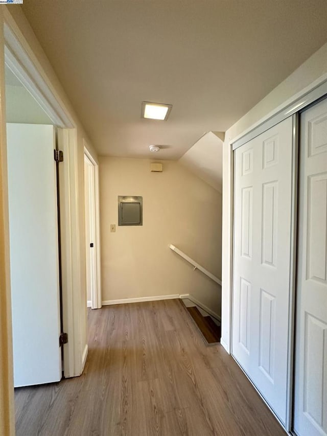 hallway featuring lofted ceiling and light wood-type flooring