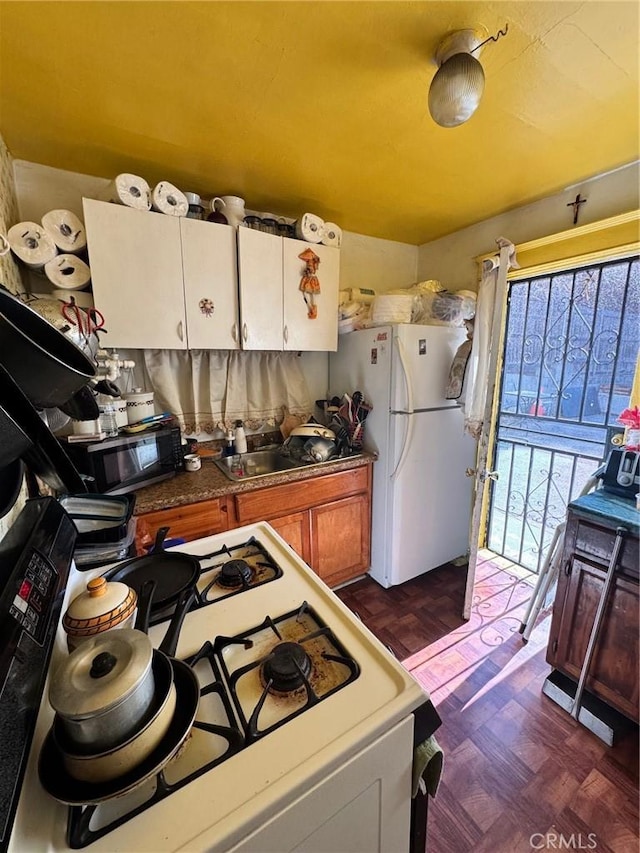 kitchen featuring white appliances and dark parquet floors