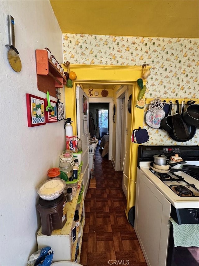 kitchen featuring white gas range and dark parquet floors