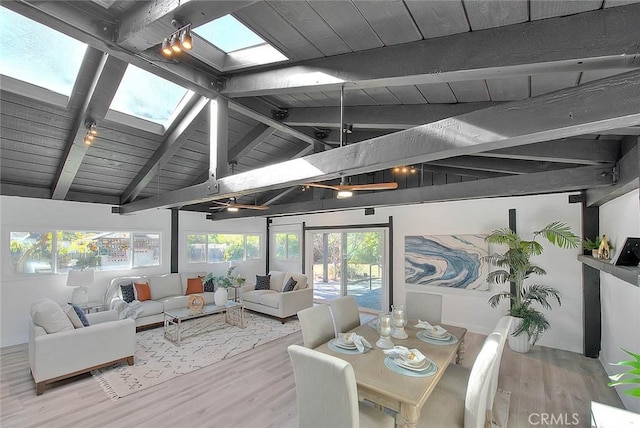 sunroom / solarium featuring vaulted ceiling with skylight, wood ceiling, and rail lighting