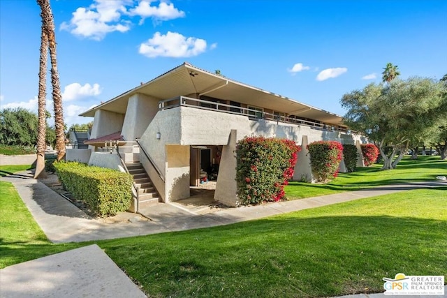 exterior space featuring a yard and a balcony