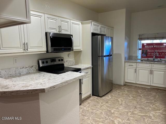 kitchen featuring sink, white cabinets, and stainless steel appliances