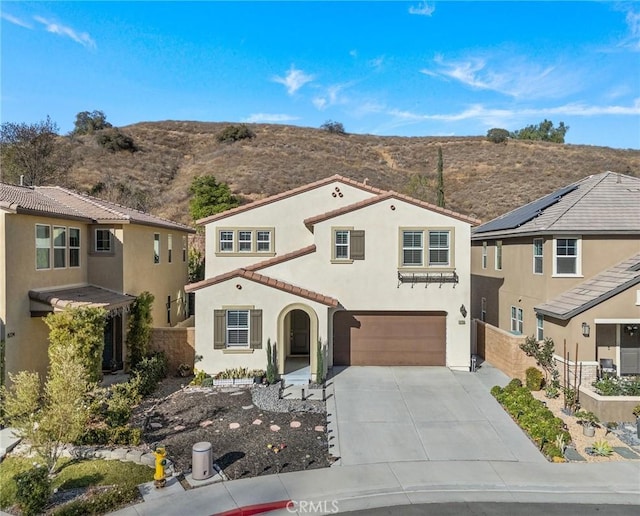 mediterranean / spanish-style home with a garage