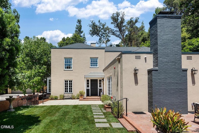 rear view of property featuring a lawn and a patio