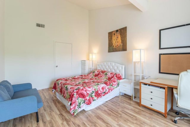 bedroom featuring high vaulted ceiling and light hardwood / wood-style flooring