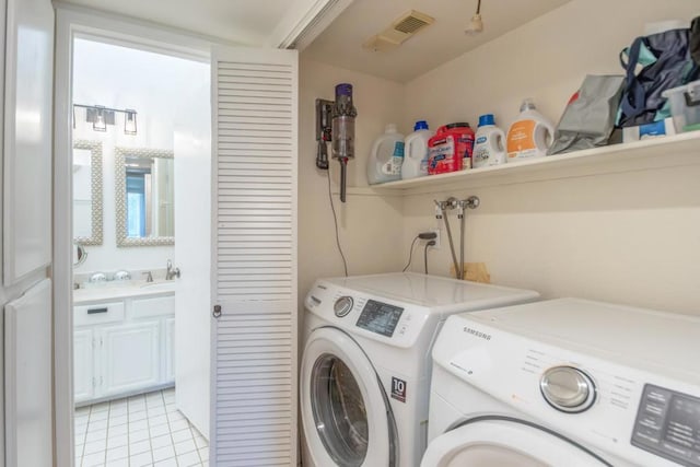 washroom featuring sink, washer and dryer, and light tile patterned flooring