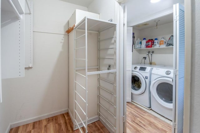 laundry room featuring independent washer and dryer and light hardwood / wood-style floors