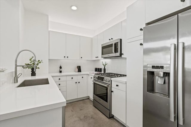 kitchen featuring stainless steel appliances, decorative backsplash, white cabinets, and sink