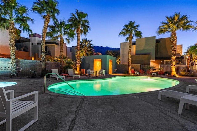 pool at dusk featuring a patio