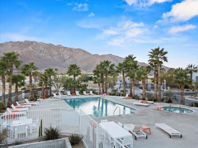 view of swimming pool featuring a mountain view, a patio area, and a community hot tub