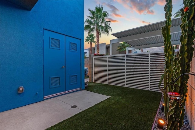 exterior entry at dusk featuring french doors and a yard