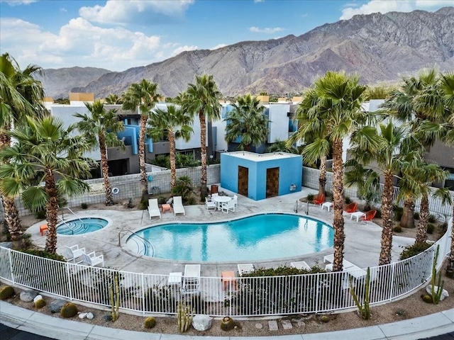 view of swimming pool with a patio, a mountain view, and a community hot tub