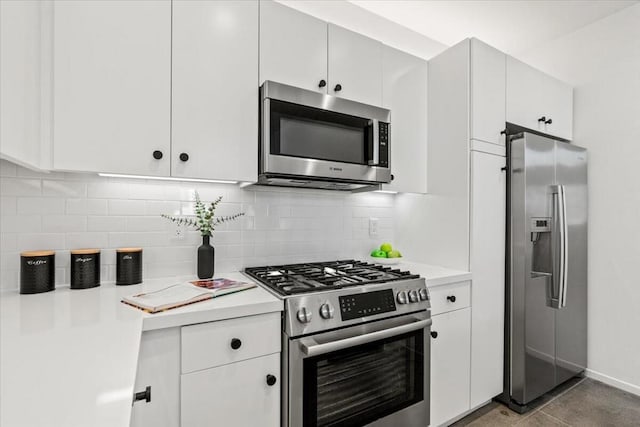 kitchen with tile patterned flooring, white cabinets, backsplash, and stainless steel appliances