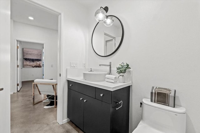 bathroom featuring toilet, vanity, and concrete floors