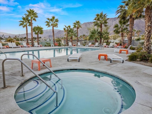 view of pool featuring a mountain view, a community hot tub, and a patio area