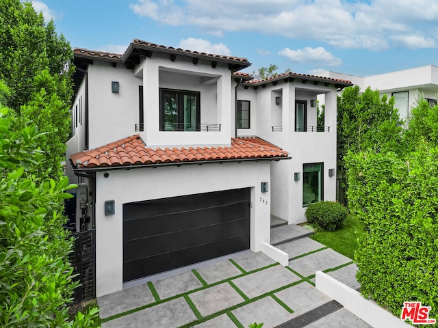 mediterranean / spanish house with a balcony and a garage