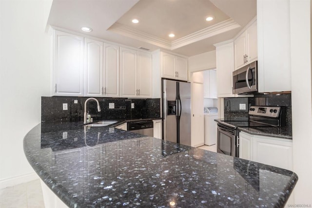 kitchen featuring kitchen peninsula, stainless steel appliances, a raised ceiling, tasteful backsplash, and white cabinets