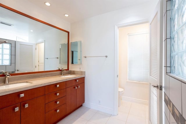 bathroom with toilet, vanity, and tile patterned flooring