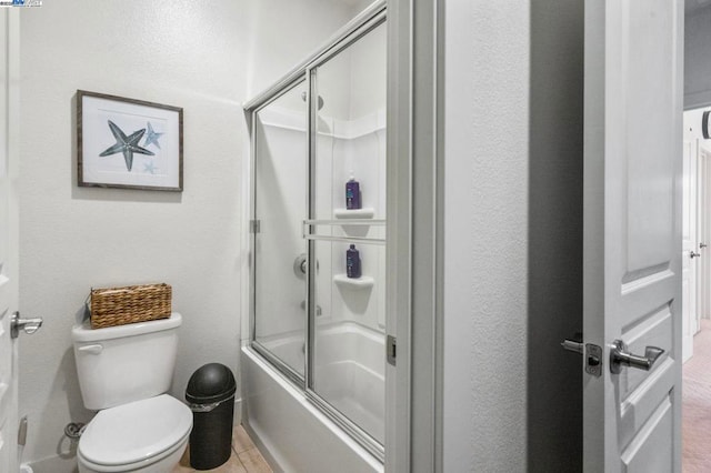 bathroom featuring toilet and enclosed tub / shower combo