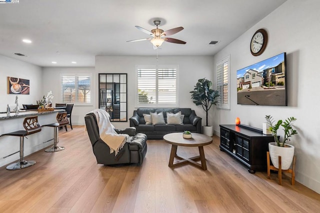 living room with ceiling fan, a healthy amount of sunlight, and light hardwood / wood-style floors