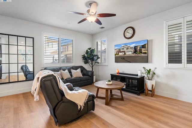 living room featuring light wood-type flooring and ceiling fan