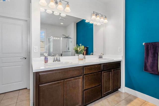 bathroom with tile patterned flooring, vanity, and a shower with door