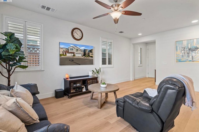 living room with light hardwood / wood-style floors, a wealth of natural light, and ceiling fan