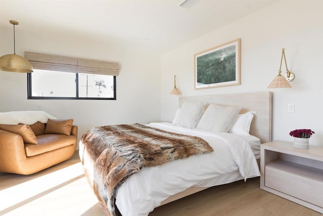 bedroom featuring wood finished floors and visible vents