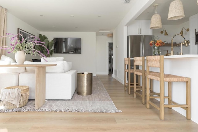 living area featuring visible vents and light wood finished floors