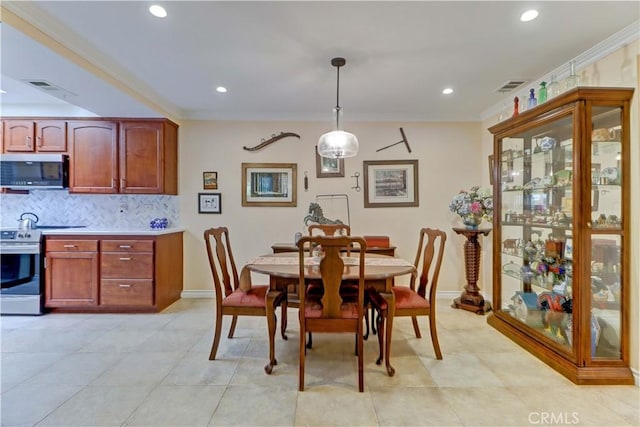 tiled dining space featuring ornamental molding