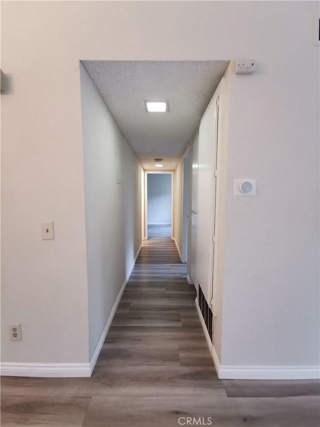 hall with dark hardwood / wood-style flooring and a textured ceiling