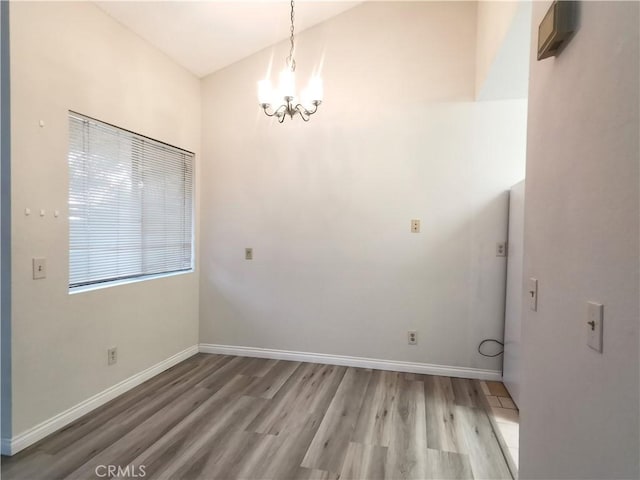 unfurnished dining area with light wood-type flooring and an inviting chandelier