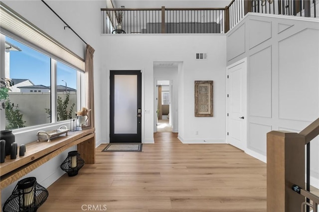 foyer with a high ceiling and light hardwood / wood-style flooring