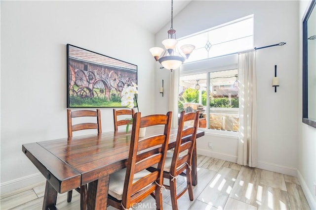 dining room featuring a notable chandelier and vaulted ceiling