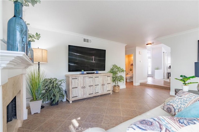 tiled living room with crown molding and a fireplace