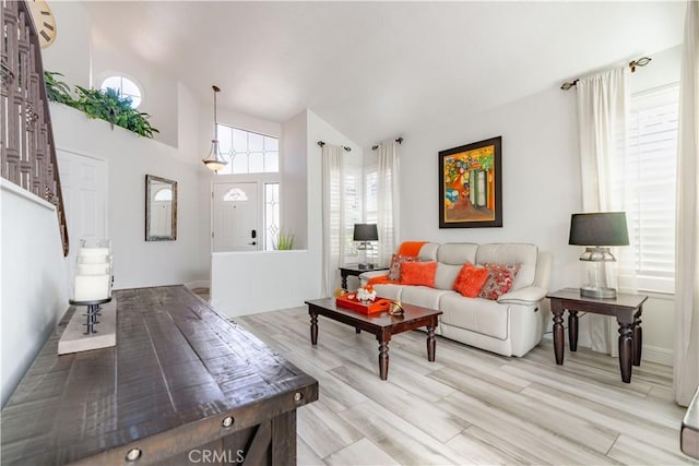 living room featuring lofted ceiling and light hardwood / wood-style floors