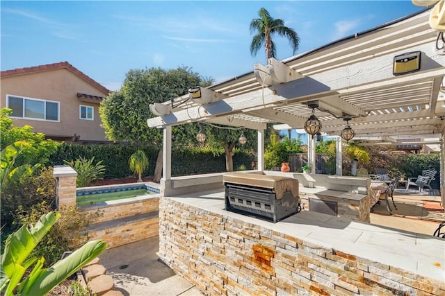 view of patio with exterior kitchen, a grill, and a pergola