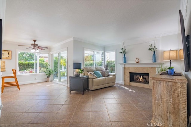 living room with a fireplace, ceiling fan, plenty of natural light, and crown molding