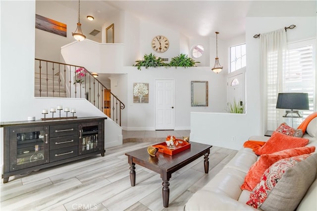 living room featuring light hardwood / wood-style floors and a towering ceiling