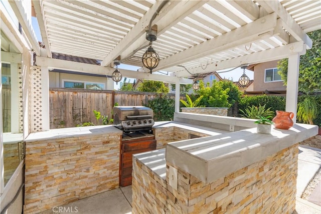 view of patio / terrace featuring exterior kitchen, a pergola, and a grill