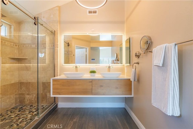 bathroom featuring a shower with door, vanity, and hardwood / wood-style floors