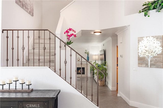 staircase with ornamental molding and a chandelier