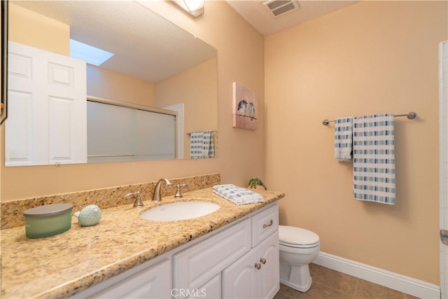 bathroom with tile patterned flooring, an enclosed shower, vanity, and toilet