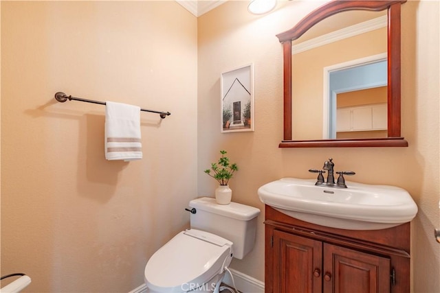 bathroom with toilet, vanity, and crown molding