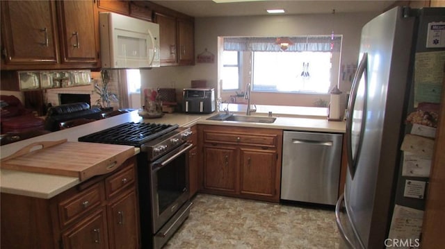 kitchen featuring a fireplace, appliances with stainless steel finishes, and sink