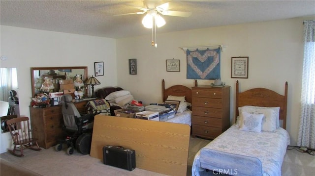 bedroom with a textured ceiling, ceiling fan, and light colored carpet